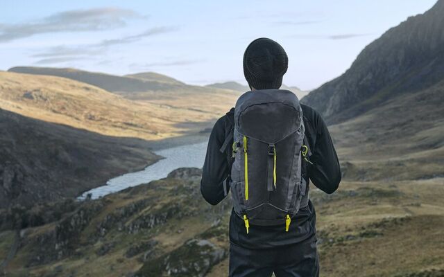 A man looking off into the distance wearing a quadra bag