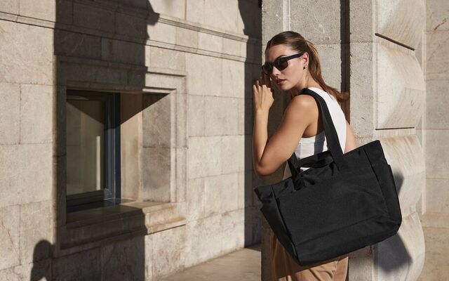 A woman wearing a BagBase bag