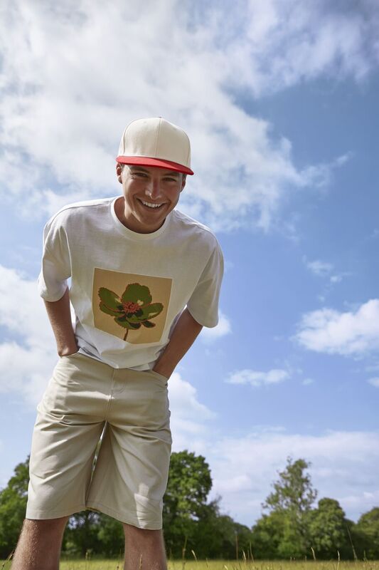 A man in a field smiling down wearing a Beechfield cap