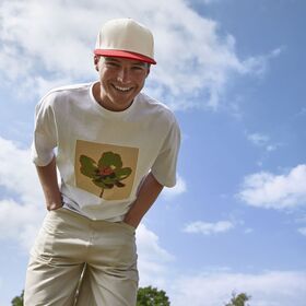 A man in a field smiling down wearing a Beechfield cap