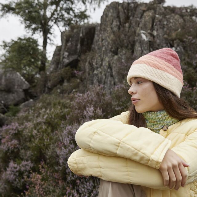 A woman sitting wearing a Beechfield Soft Wave Beanie